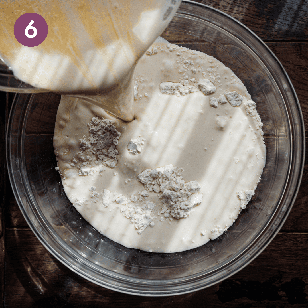 action shot of pouring liquid ingredients into dry ingredients for pancake batter.