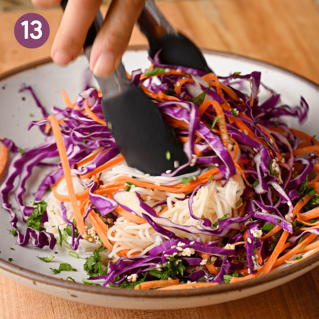 person tossing the salad with tongs.