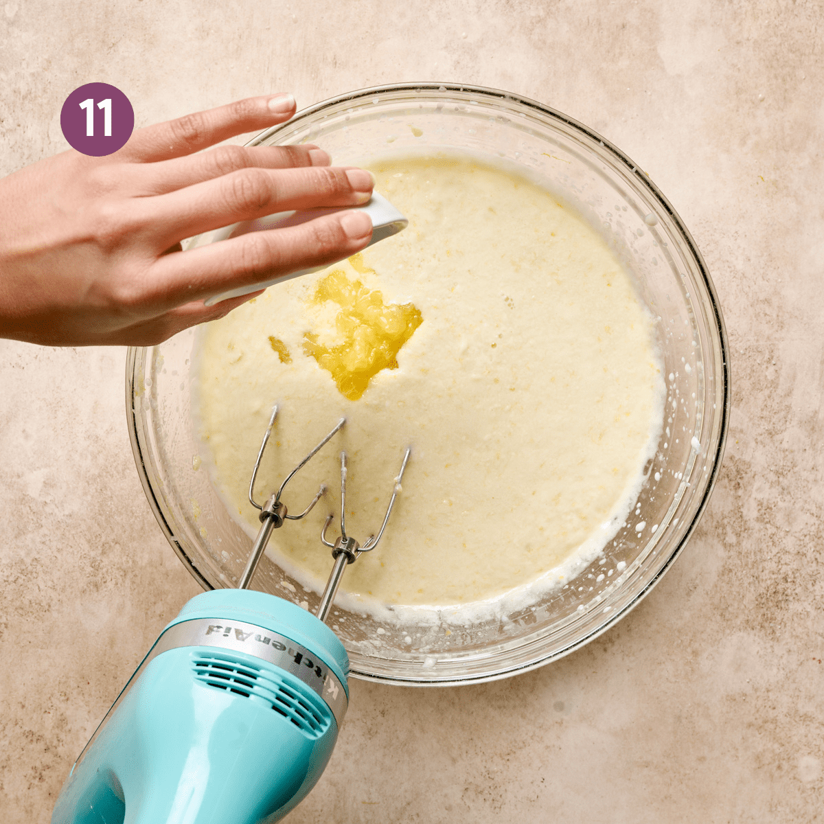 woman's hands pouring in chopped lemons into a glass bowl with liquid ingredients for a cake.