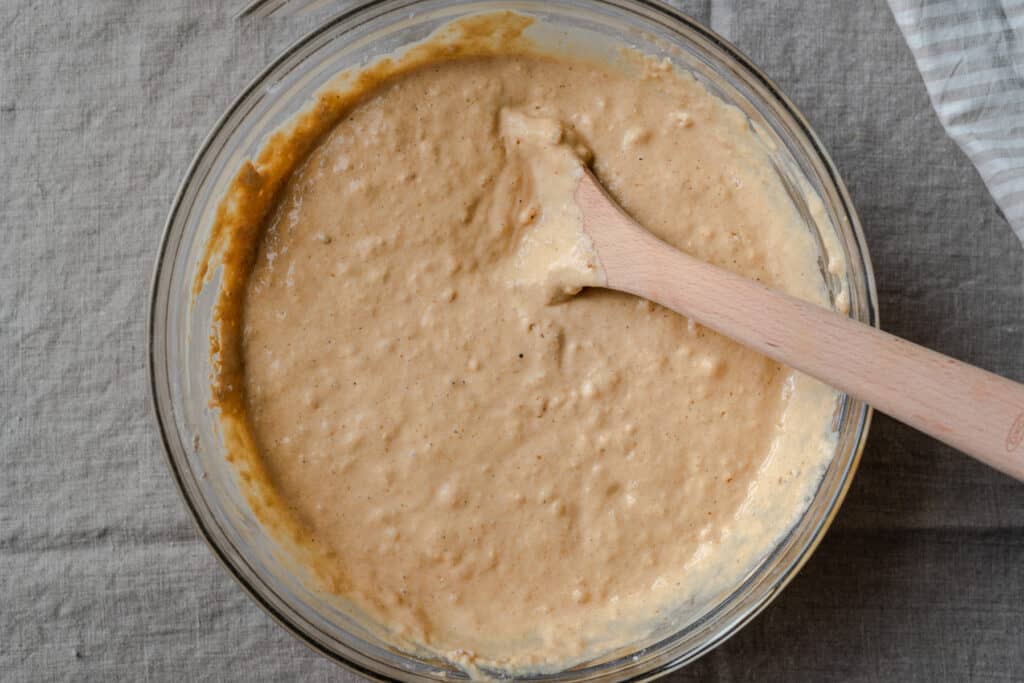 pumpkin pancake batter in a bowl with wooden spoon