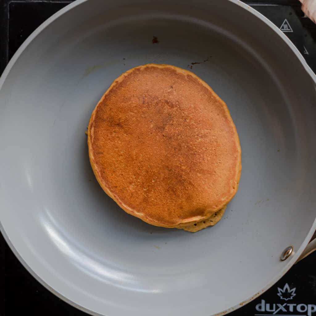 golden pancake cooking in skillet