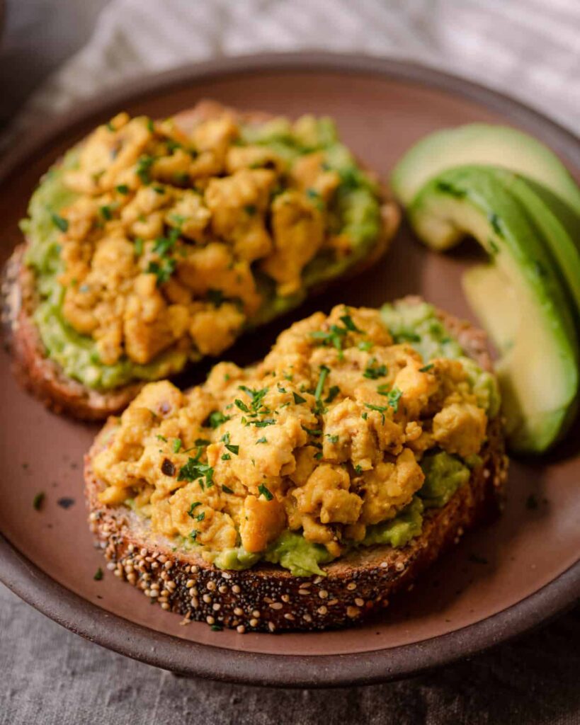 tofu scramble with toast on a plate next to a cup of coffee.